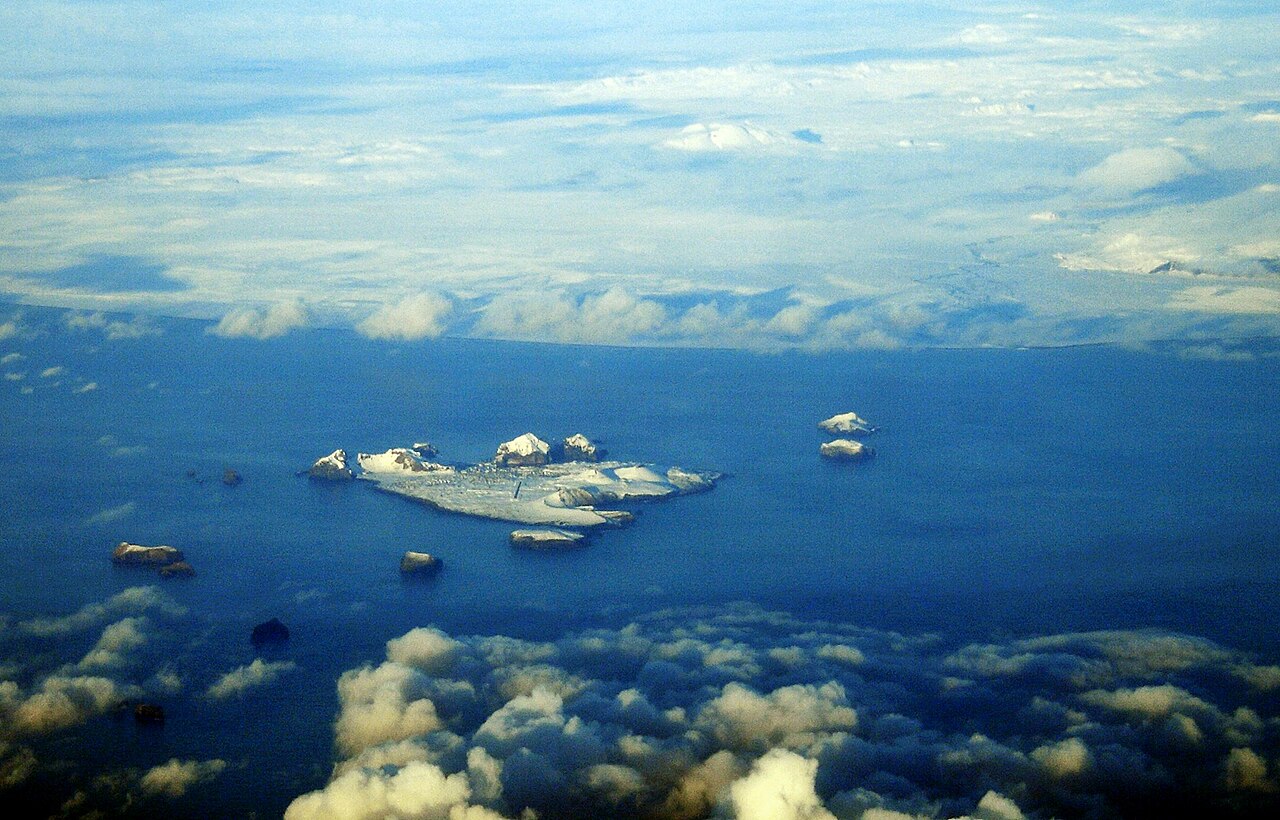 Snow-covered Westman Islands sit in a blue sea, with the Icelandic mainland beyond.